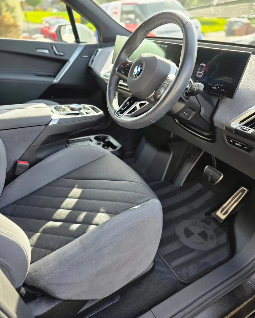 Grey front seat, steering wheel and floor mats in sunlight after a VDS clean