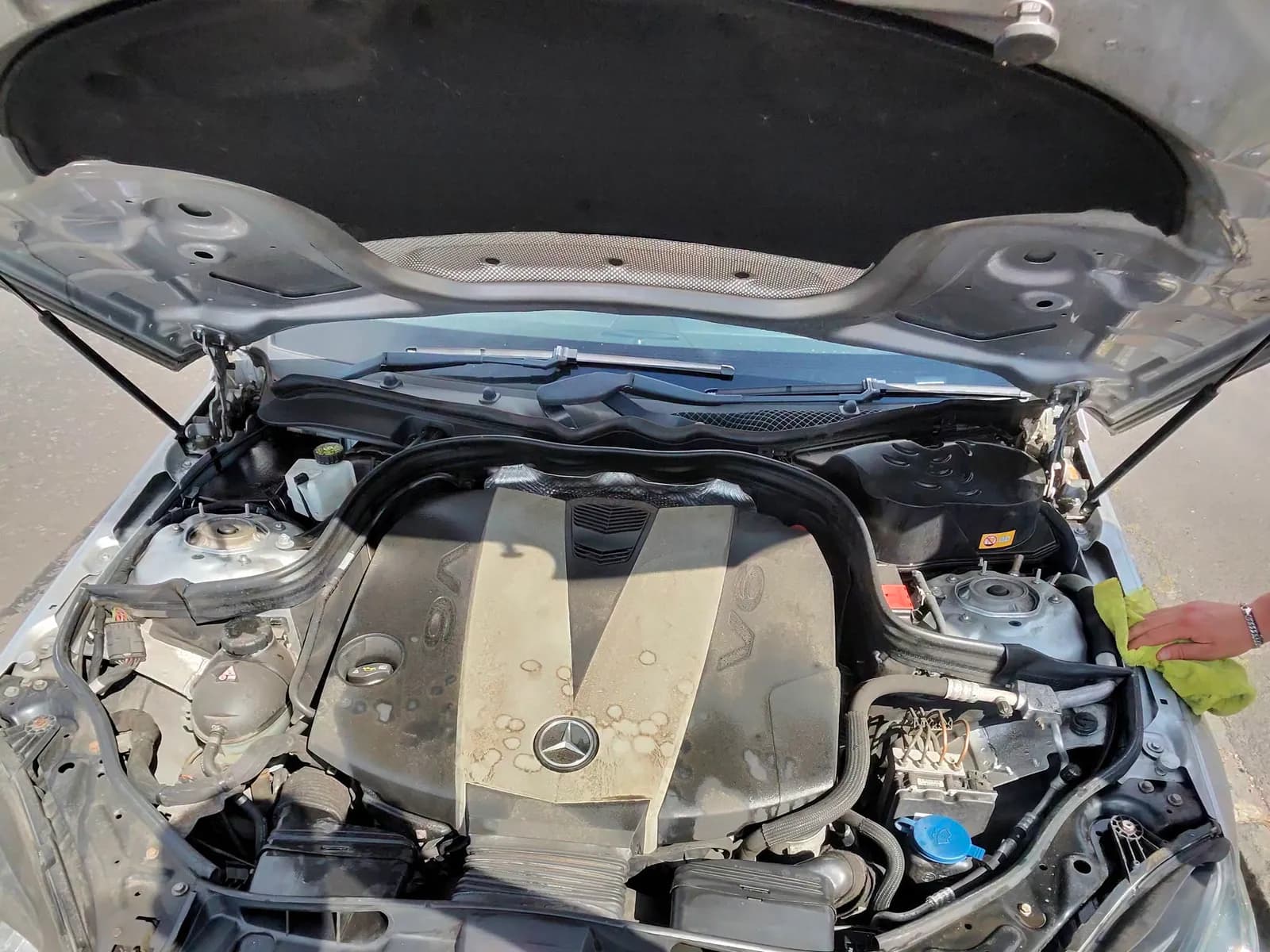 Mercedes V6 engine cover being wiped down by hand during a mobile engine bay clean