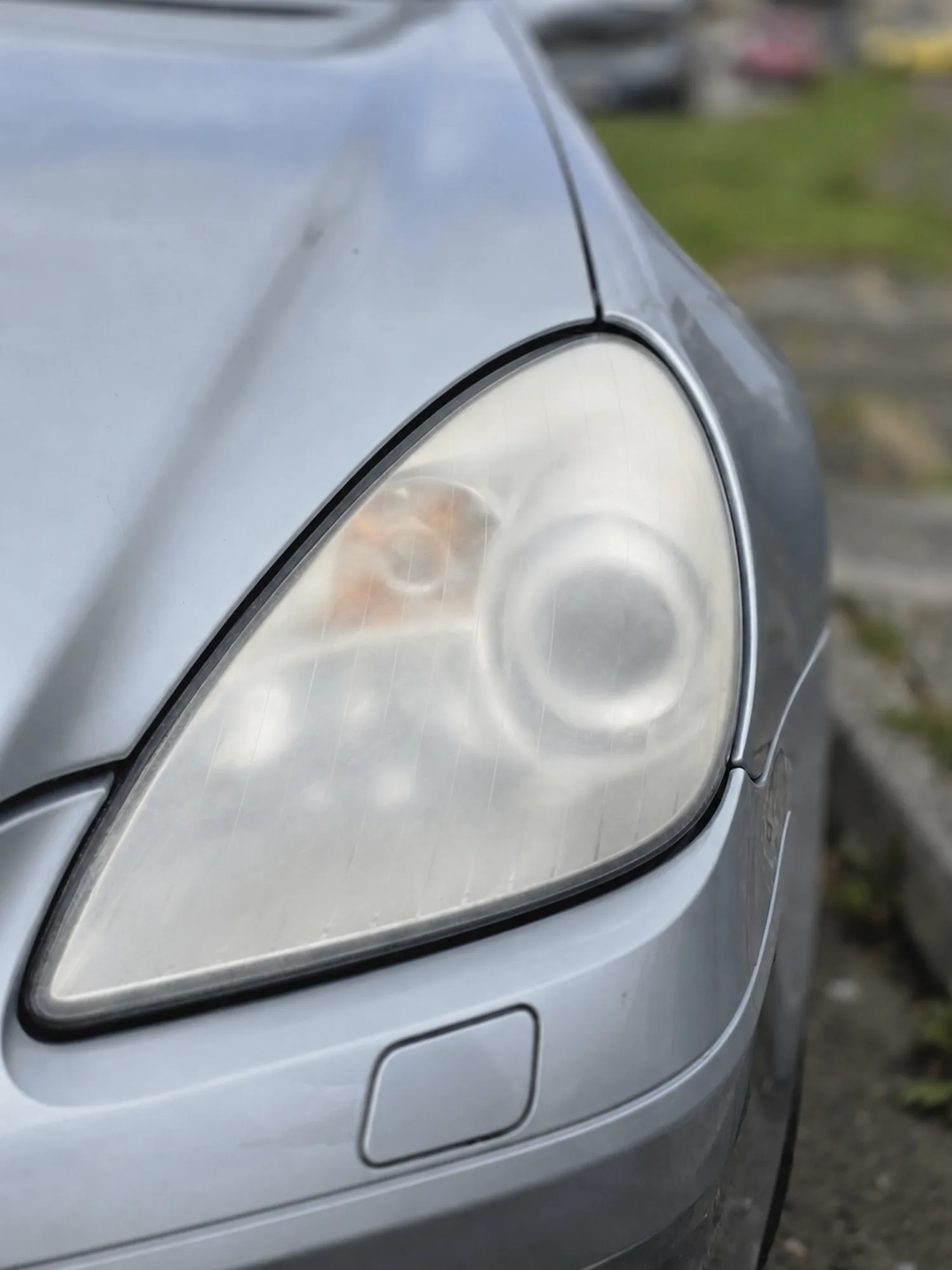 Cloudy, yellowed and oxidised headlight lens before restoration